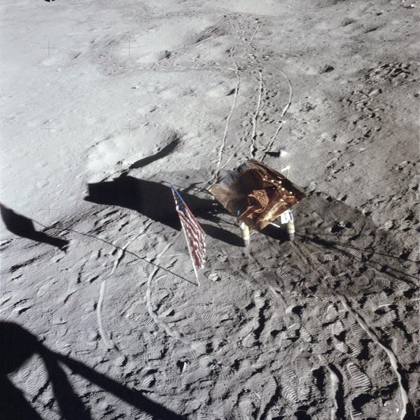 Footprints, wheel tracks and the Rickshaw–type portable workbench on the Moon, with the US flag in 1971. NASA